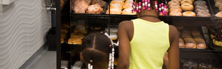 Photo of children selecting donuts from pastery case.