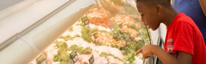 Photo of boy choosing seafood item.